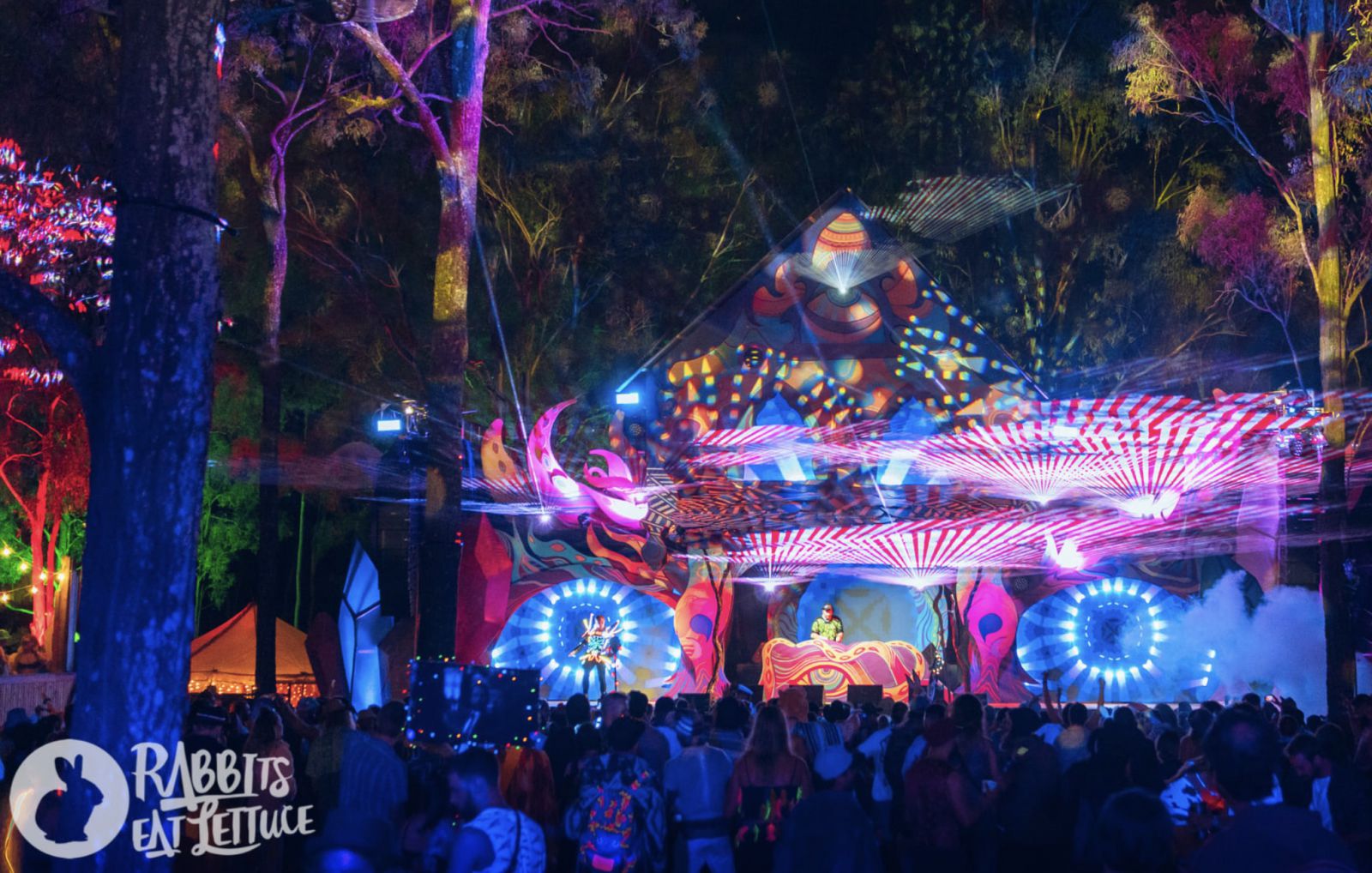 A DJ play in front of the crowd at the Australian Rabbit Eats Lettuce Music Festival on a stage that is swirling with trippy colourful lights